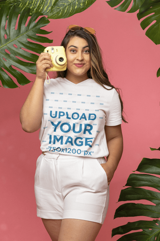 V Neck T Shirt Mockup Of A Woman Posing At A Summer Themed Studio With A Camera In Her Hand