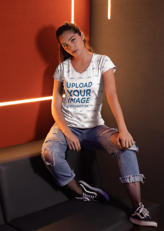 V Neck Tee Mockup Of A Girl Sitting Against Cool Led Lights