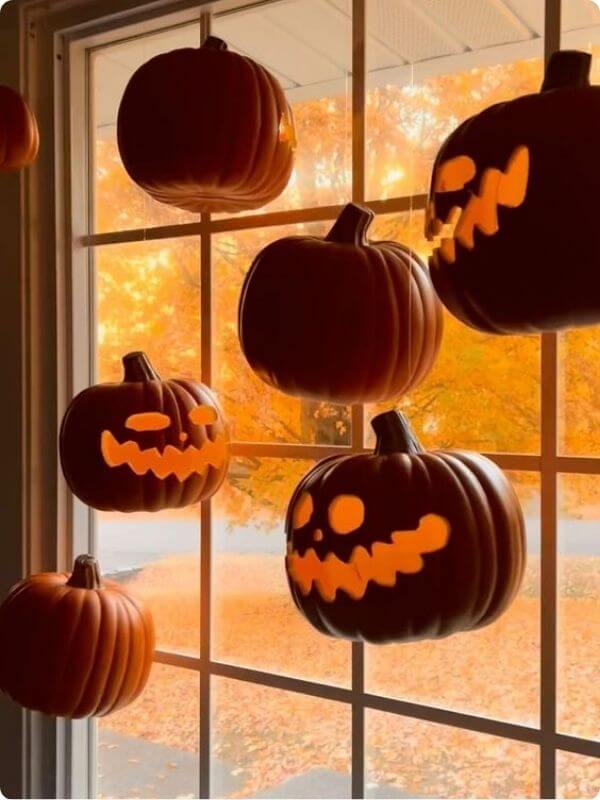 A Set Of Pumpkins Hanging In Front Of A Window