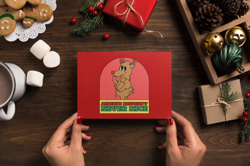 Cozy Mockup Of A Holiday Greeting Card Held By A Woman's Hands Featuring A Reindeer Cartoon