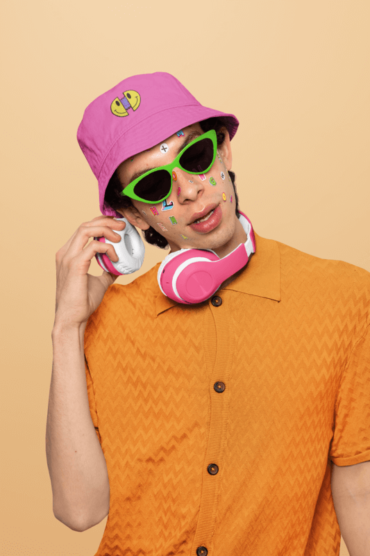 Bucket Hat Mockup Of A Man With Face Stickers A Smiley Face Design And Headphones On A Yellow Backdrop