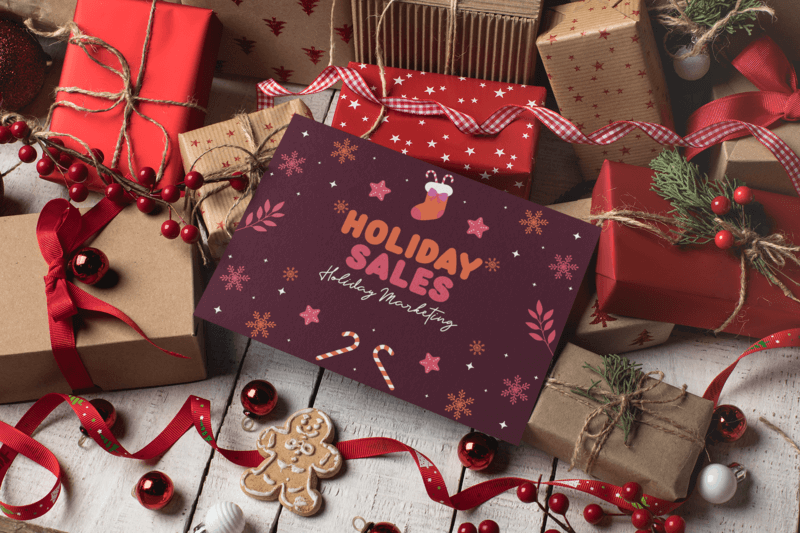 Mockup Of A Christmas Card Over Gift Boxes And Red Decorations With A Holiday Sale Text