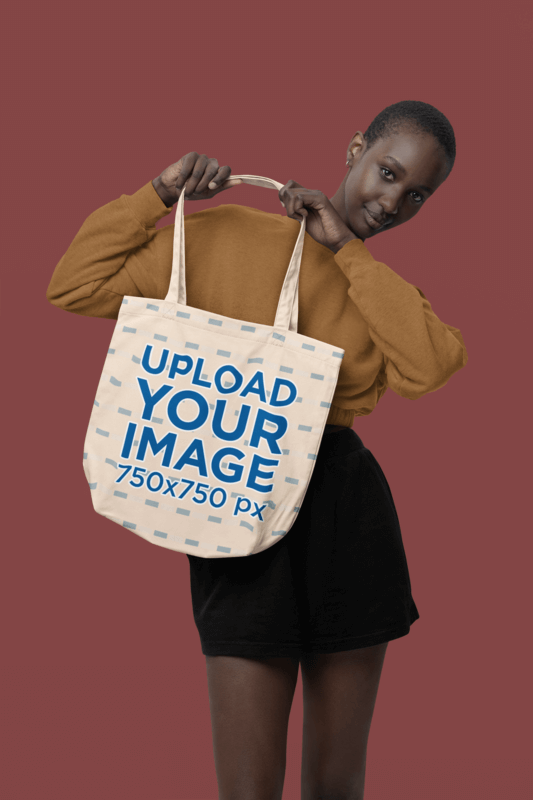 Mockup Of A Woman With Short Hair Showing An Econscious Tote Bag To The Camera