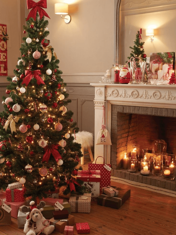 A Cozy And Warm Living Room With A Pretty Christmas Tree And Christmas Decorations Next To A Chimney