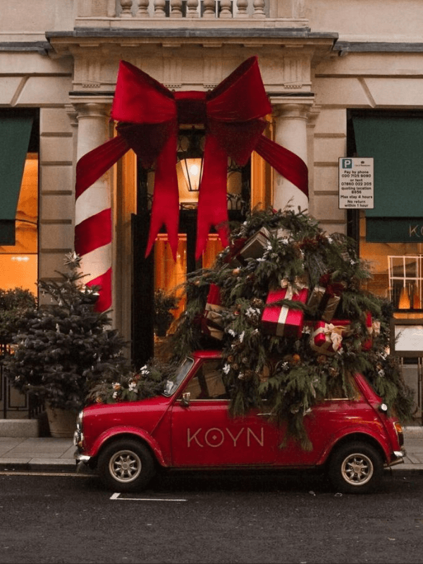 A Red Car With A Christmas Tree On Top, Ready To Celebrate The Season