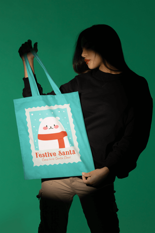 Mockup Of A Woman Showcasing A Christmas Tote Bag In A Studio