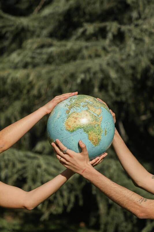 Photo Of A Pair Of Hands Holding A Globe By Pexels