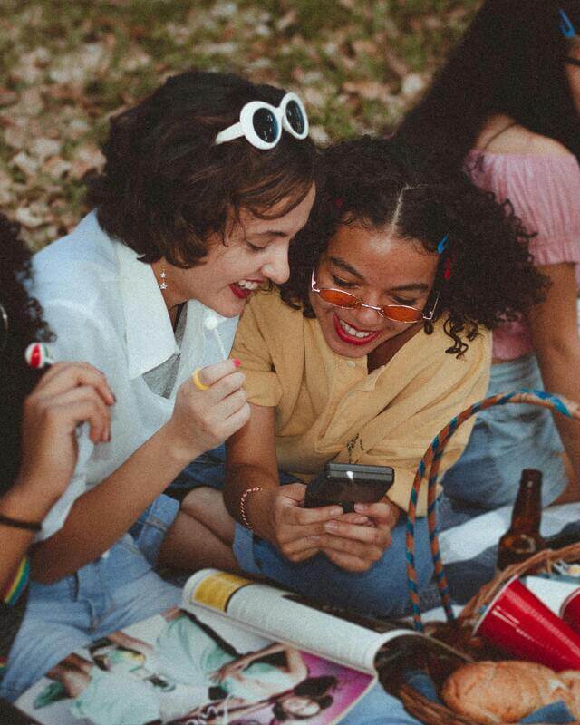 Photo Of Teenage Girls Sitting In The Grass Laughing By Pexels