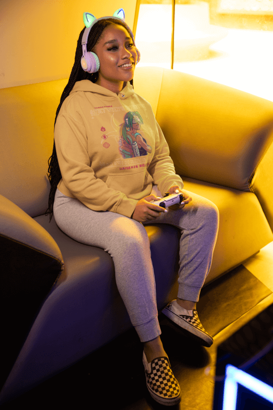 Hoodie Mockup Of A Female Gamer With Headphones Playing Video Games At Home