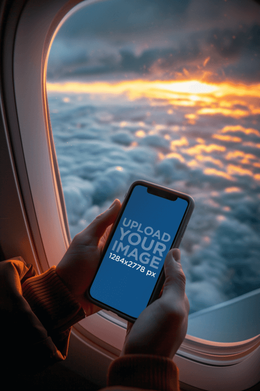 iPhone 12 Mockup Of A Person Taking A Picture Of The Sky From A Plane Window Created With Placeit's AI Mockup Generator