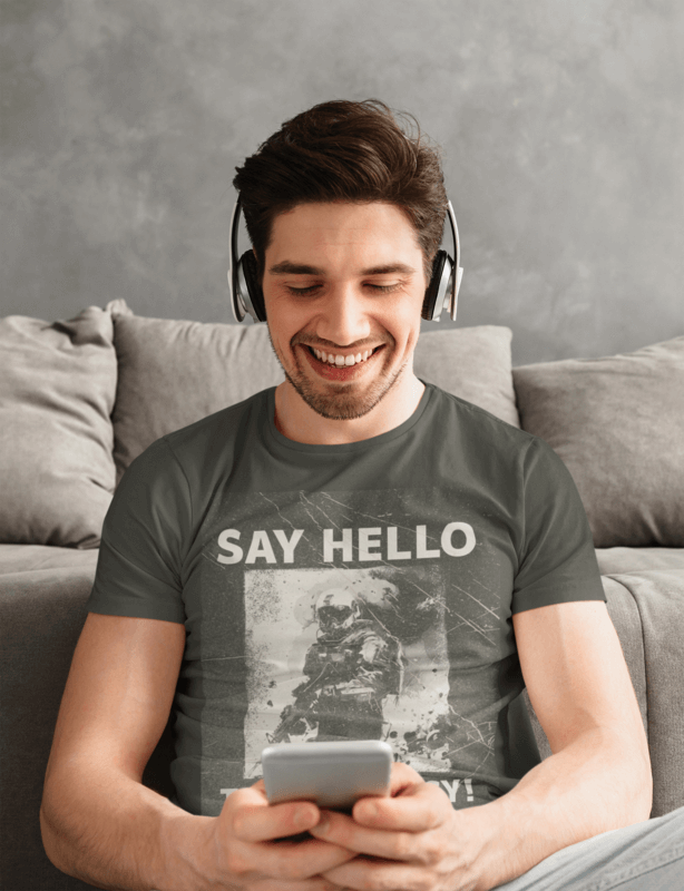 T Shirt Mockup Of A Man Playing On His Cellphone At Home