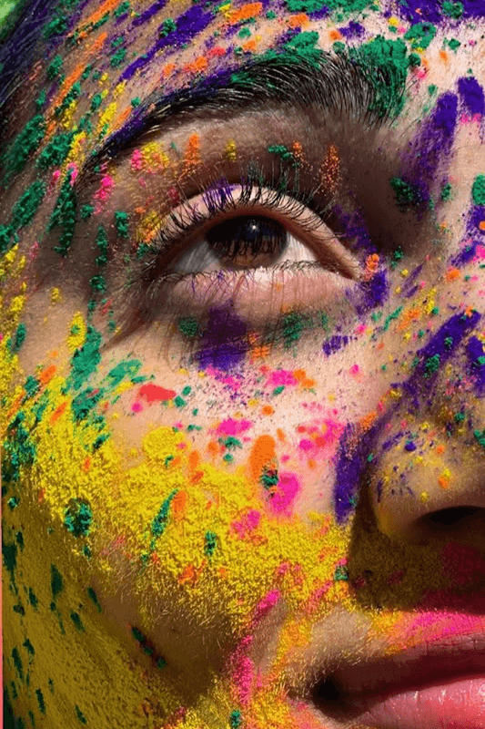 A Close Up Shot Of A Woman Covered In Vibrant Gulaal Powders, Exuding A Hopeful And Aesthetic Vibe