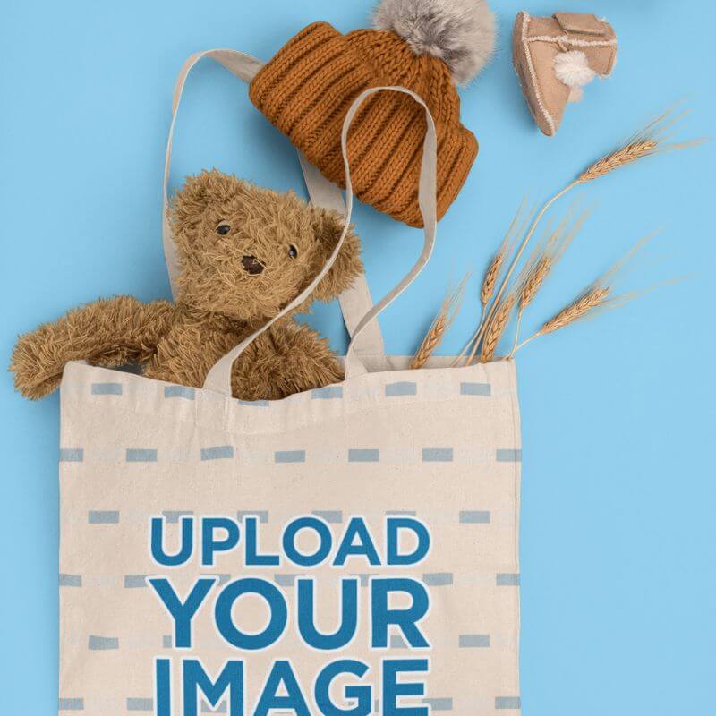 Tote Bag Mockup Featuring A Teddy Bear And Baby Garments