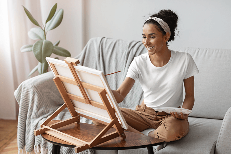 T Shirt Mockup Featuring A Woman Painting At Home