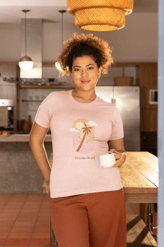 Bella Canvas 6400 T Shirt Mockup Of A Woman Leaning Against A Wooden Table And Holding A Cup Of Coffee